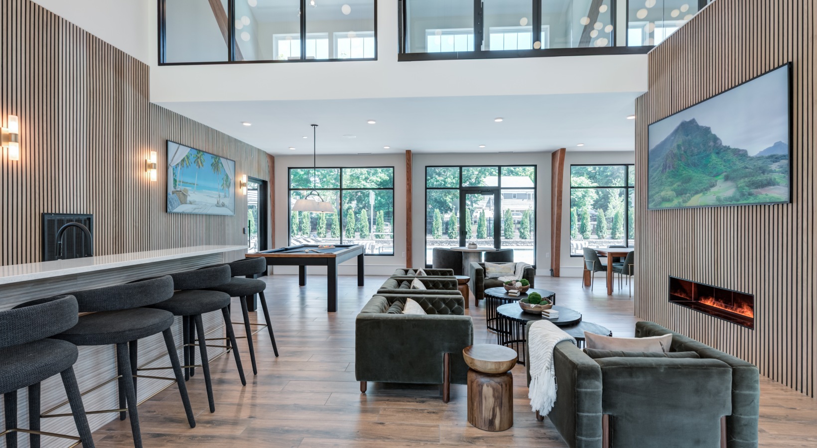 Upscale resident clubroom and community lounge with modern seating, fireplace, and bar area at Brookside Wilton in CT