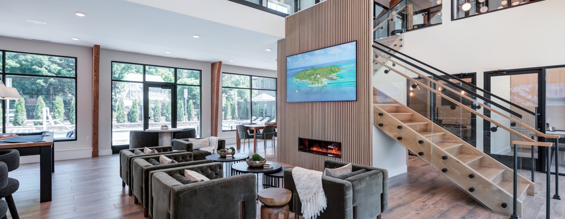Modern, sunlit resident clubhouse and professional coworking area featuring high ceilings and glass doors at Brookside Wilton in CT