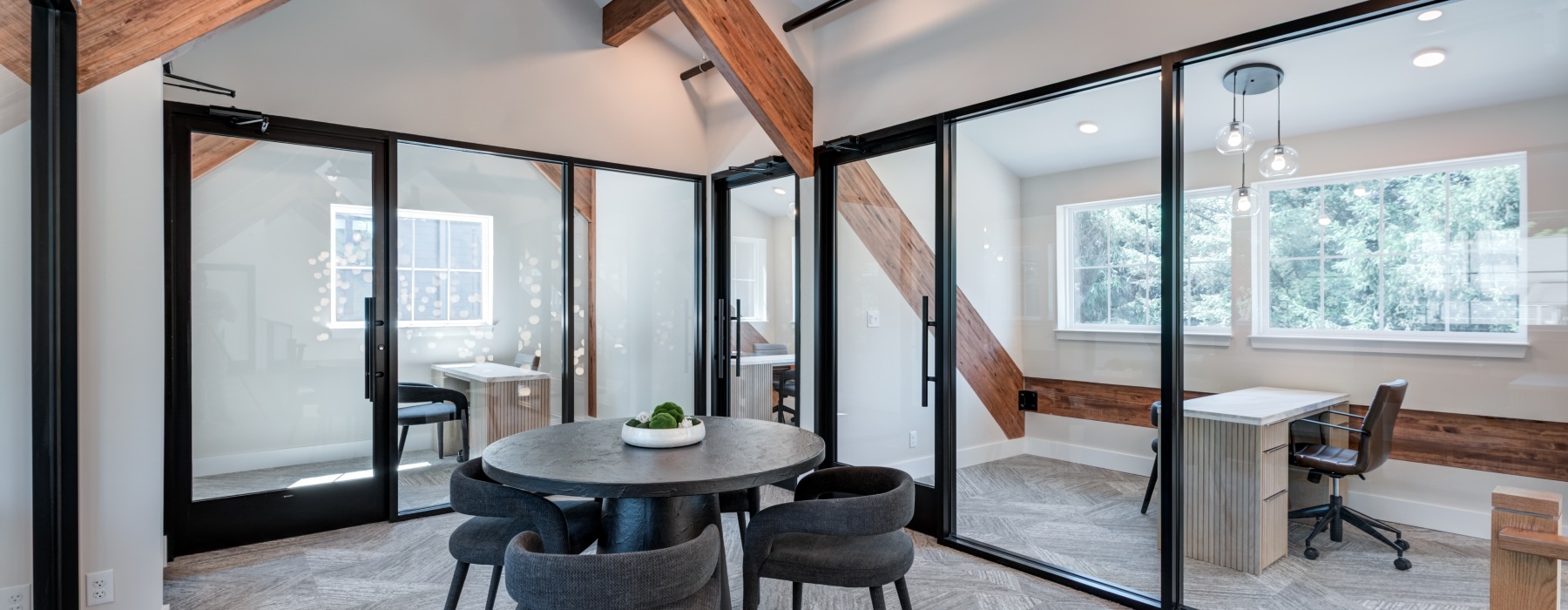 Modern open-concept coworking space and resident lounge with glass-walled conference rooms and comfortable seating at Brookside Wilton in CT